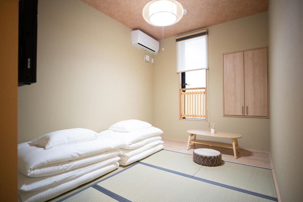 une chambre avec un lit, une table et une fenêtre dans l'établissement Onya Kaede, à Kyoto
