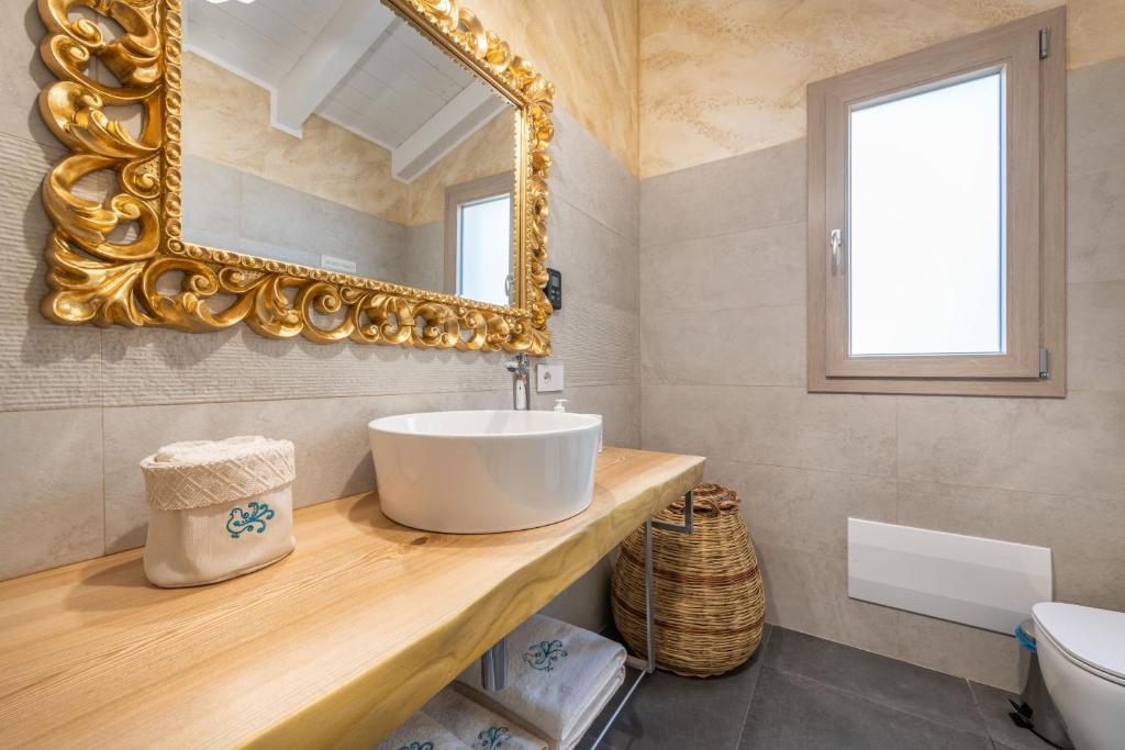 une salle de bain avec un lavabo et un miroir dans l'établissement Villa Sa Rocca Junior & Suite, à Chia