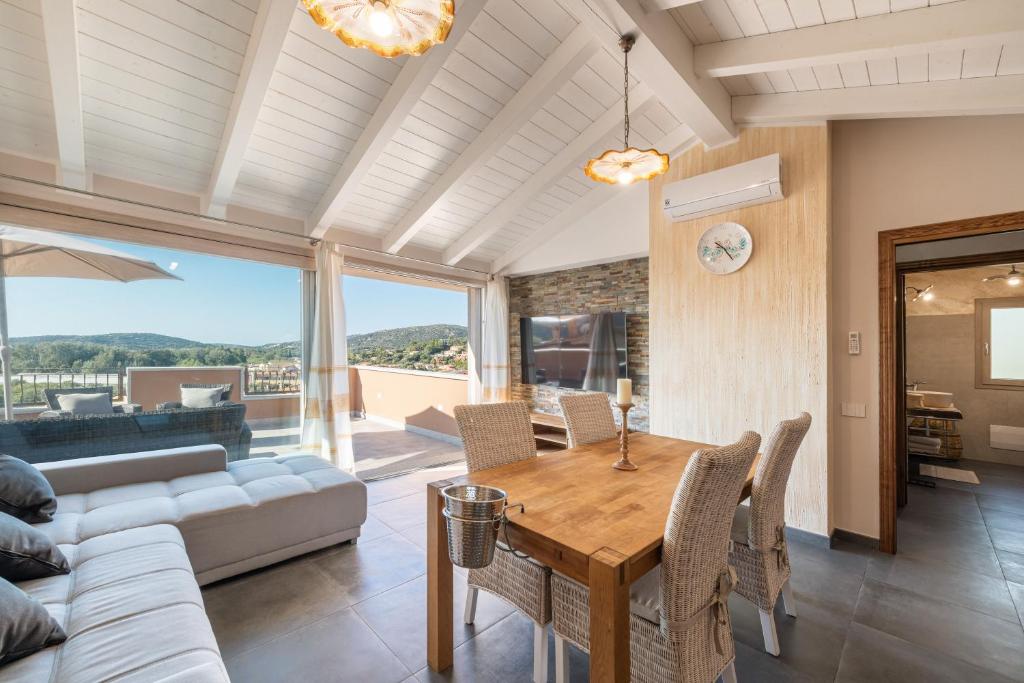 un salon avec une table et un canapé dans l'établissement Villa Sa Rocca Junior & Suite, à Chia