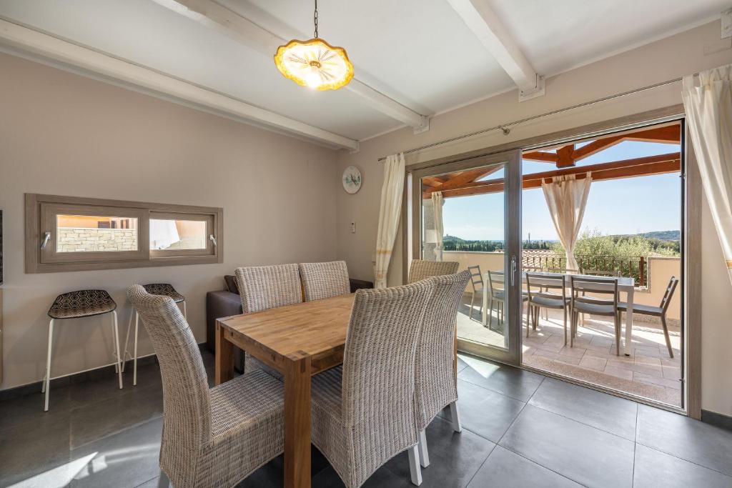 une salle à manger avec une table et des chaises en bois dans l'établissement Villa Sa Rocca Manna, à Chia