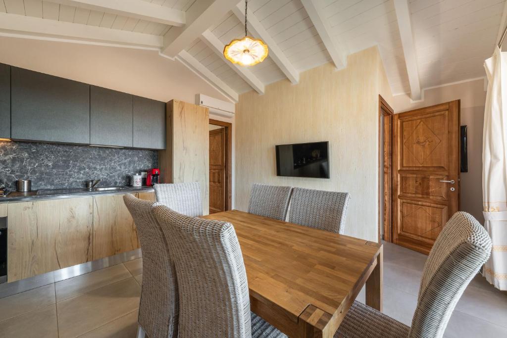 une salle à manger avec une table et des chaises en bois dans l'établissement Villa Sa Rocca Junior & Suite, à Chia