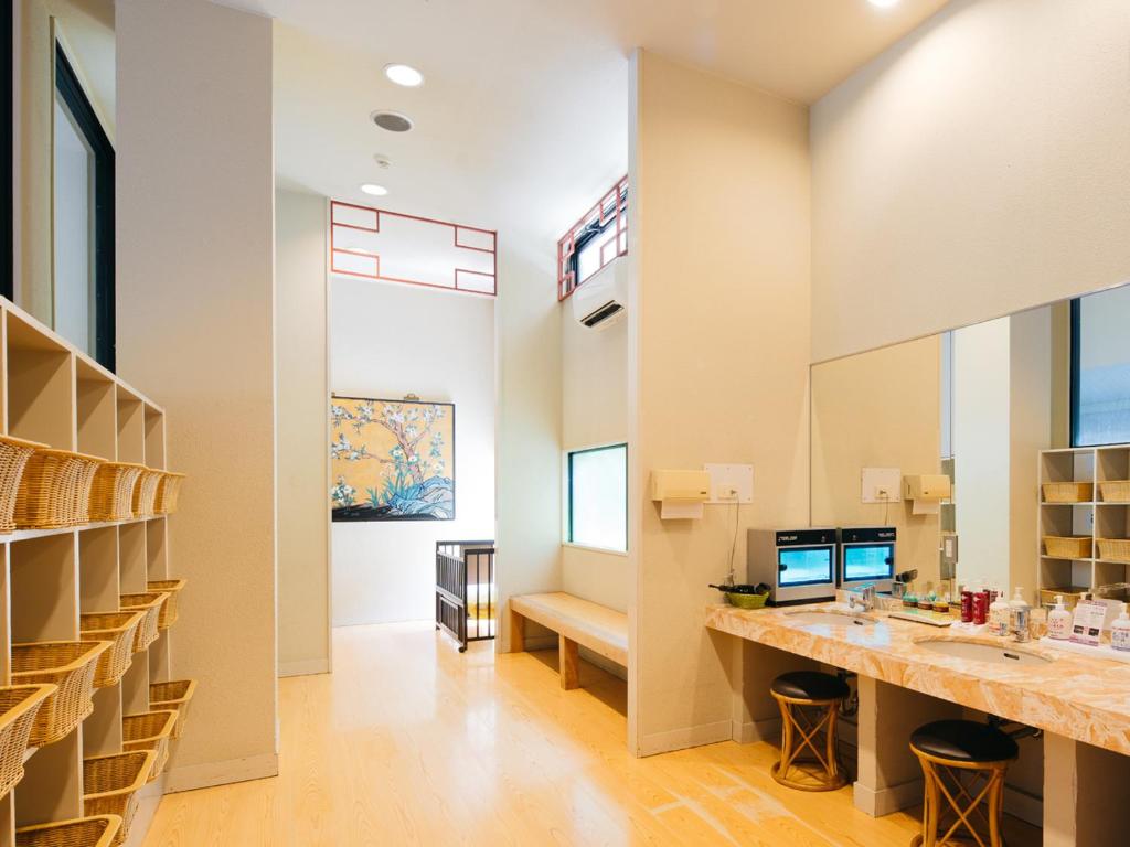 une salle de bain avec deux lavabos et un grand miroir dans l'établissement Gyokusenkaku, à Nagato