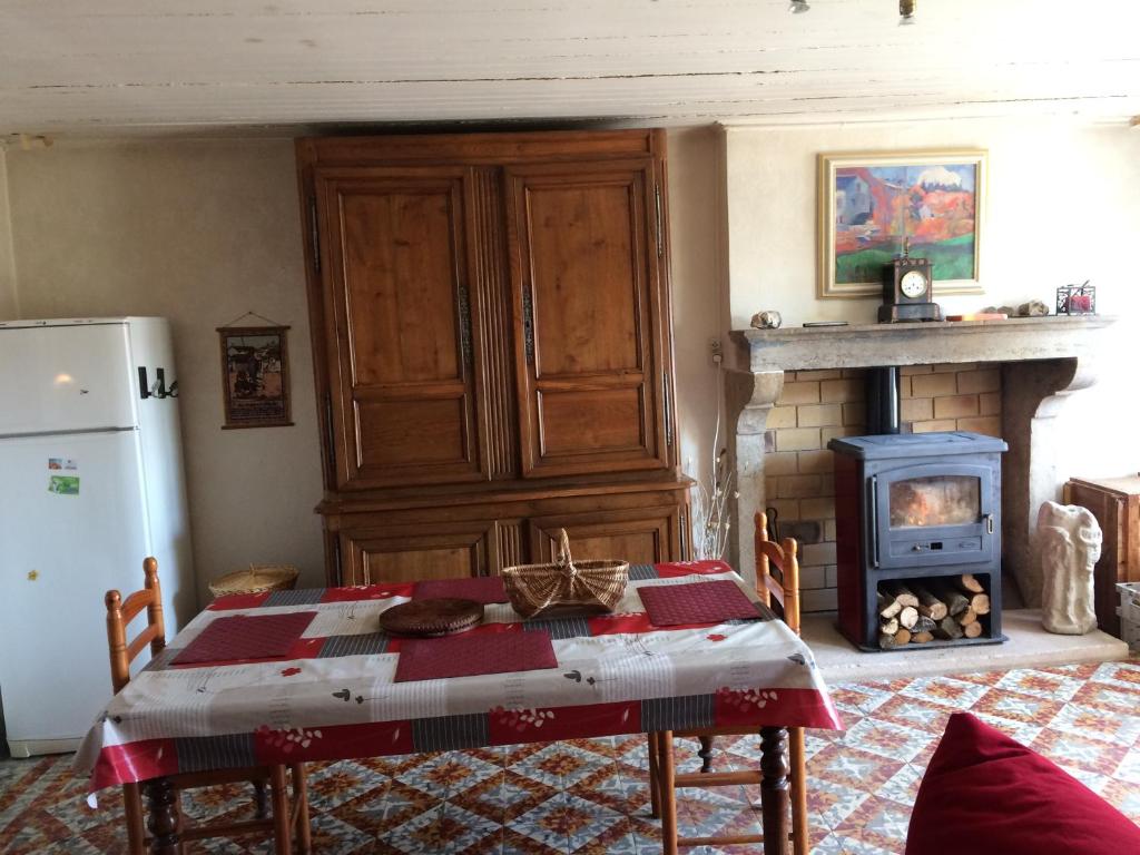 un salon avec une table et une cheminée dans l'établissement Le Maquis, à Charmes