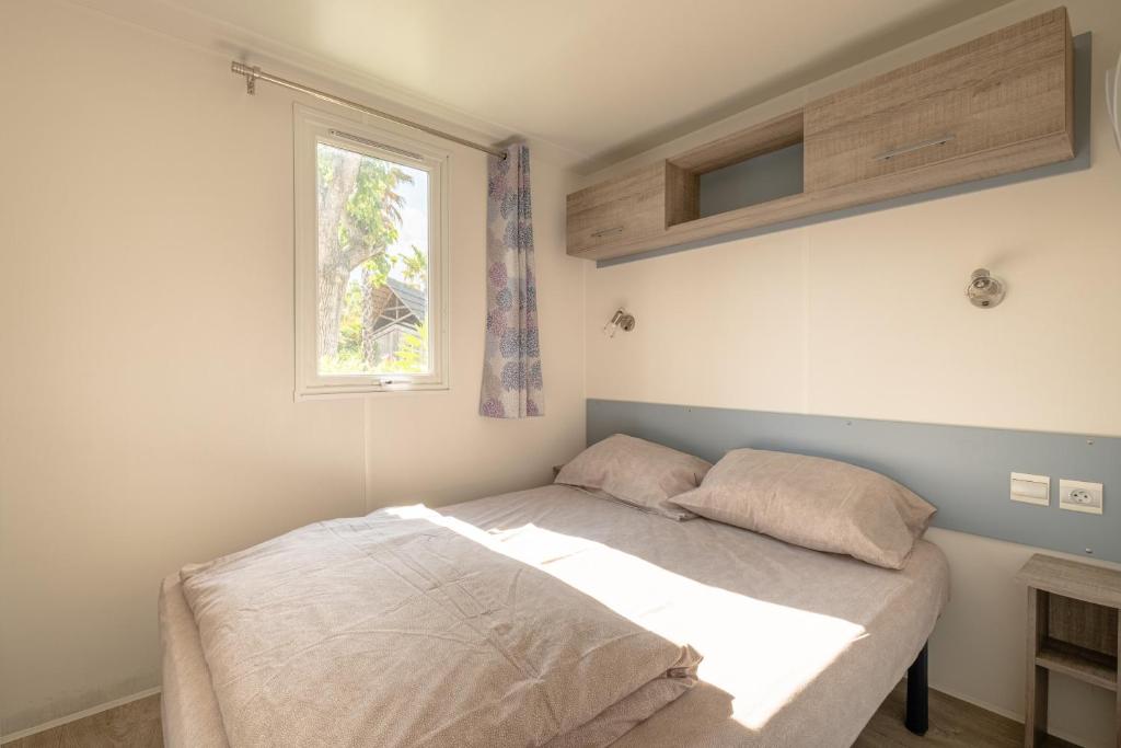 un lit dans une chambre avec une fenêtre dans l'établissement DS One Vacances, Prairies de la Mer, à Grimaud 37 autres photos