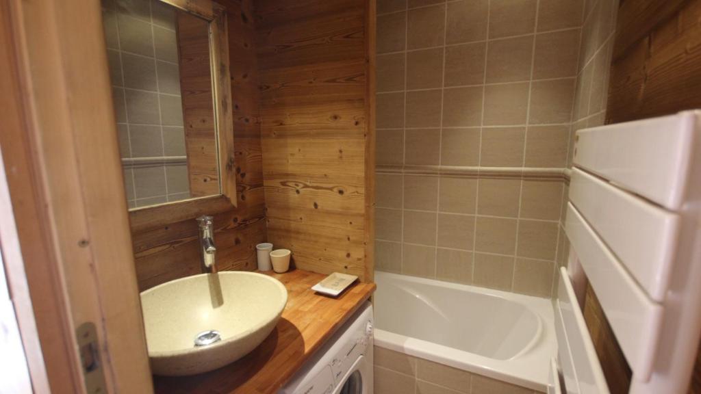 une petite salle de bain avec un lavabo et une baignoire dans l'établissement Appartement au lac ski aux pieds, à Tignes