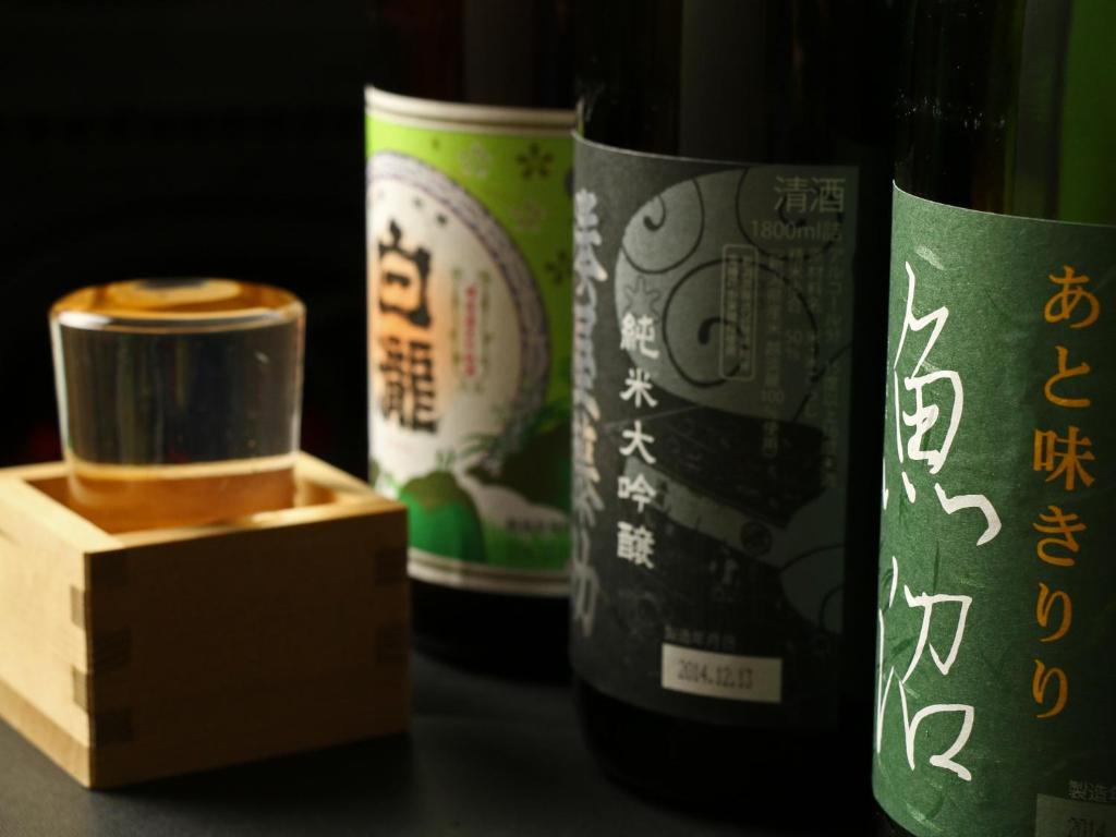 un groupe de trois bouteilles de vin à côté d'une boîte dans l'établissement Warabiso, à Yuzawa