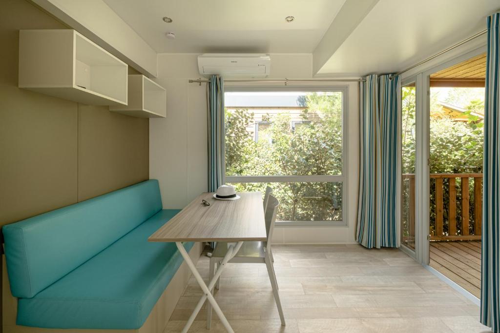 une salle à manger avec un banc bleu et une table dans l'établissement DS One Vacances, Prairies de la Mer, à Grimaud