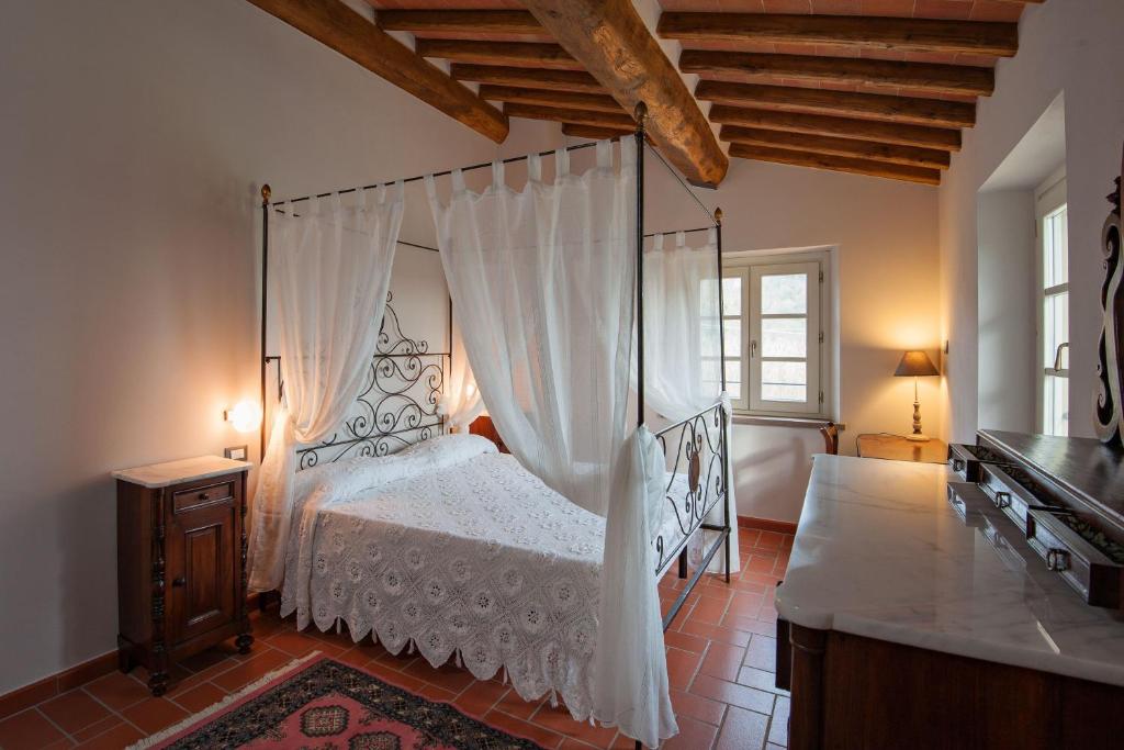 une chambre avec un lit à baldaquin dans l'établissement Villa con piscina, à Capannori