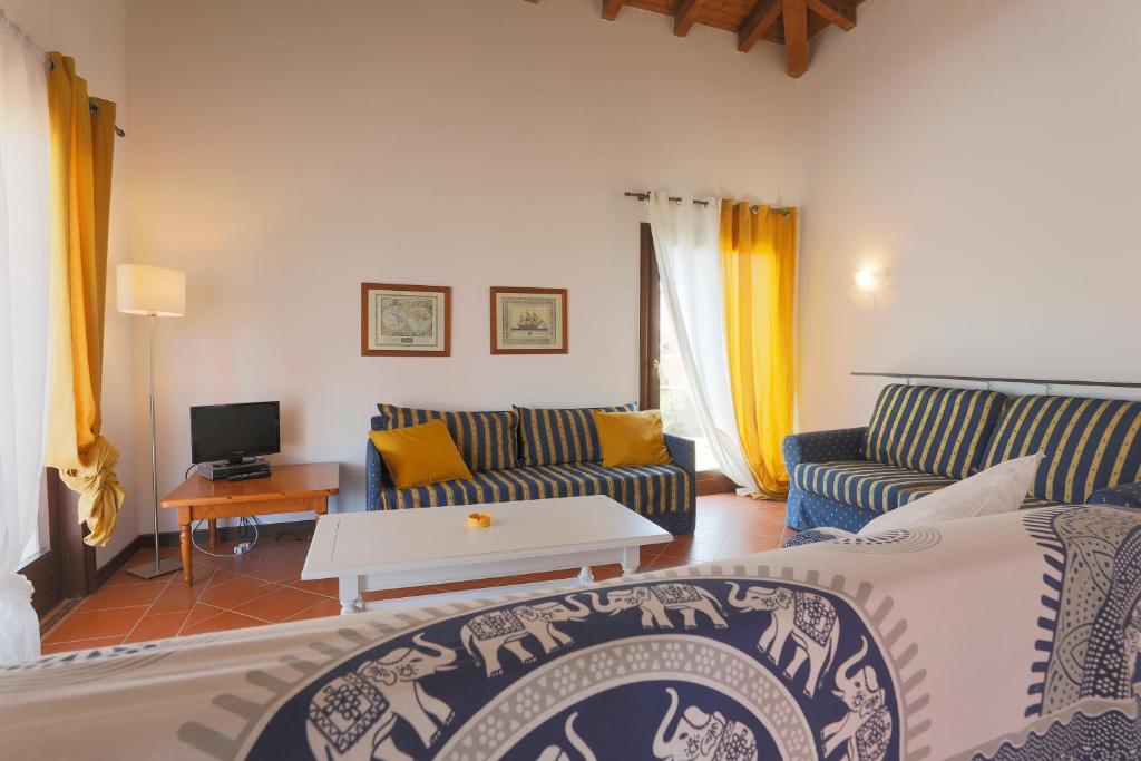 un salon avec deux canapés et une télévision dans l'établissement Villa Allegra, à Stintino