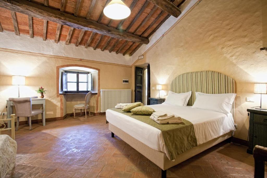 une chambre avec un lit et un bureau dans une pièce dans l'établissement Villa Ruffignano, à Cortone