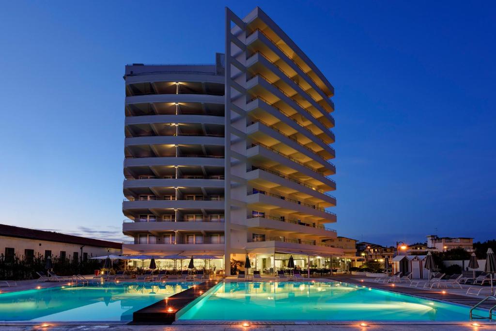 un hôtel avec une piscine devant un bâtiment dans l'établissement Adriatic Palace Hotel, à Lido di Jesolo