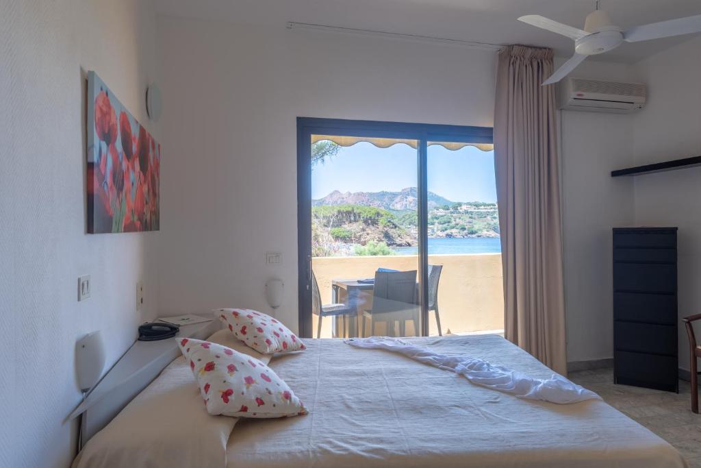 une chambre avec un lit avec vue sur la plage dans l'établissement Residence Le Acacie, à Capoliveri 223 autres photos