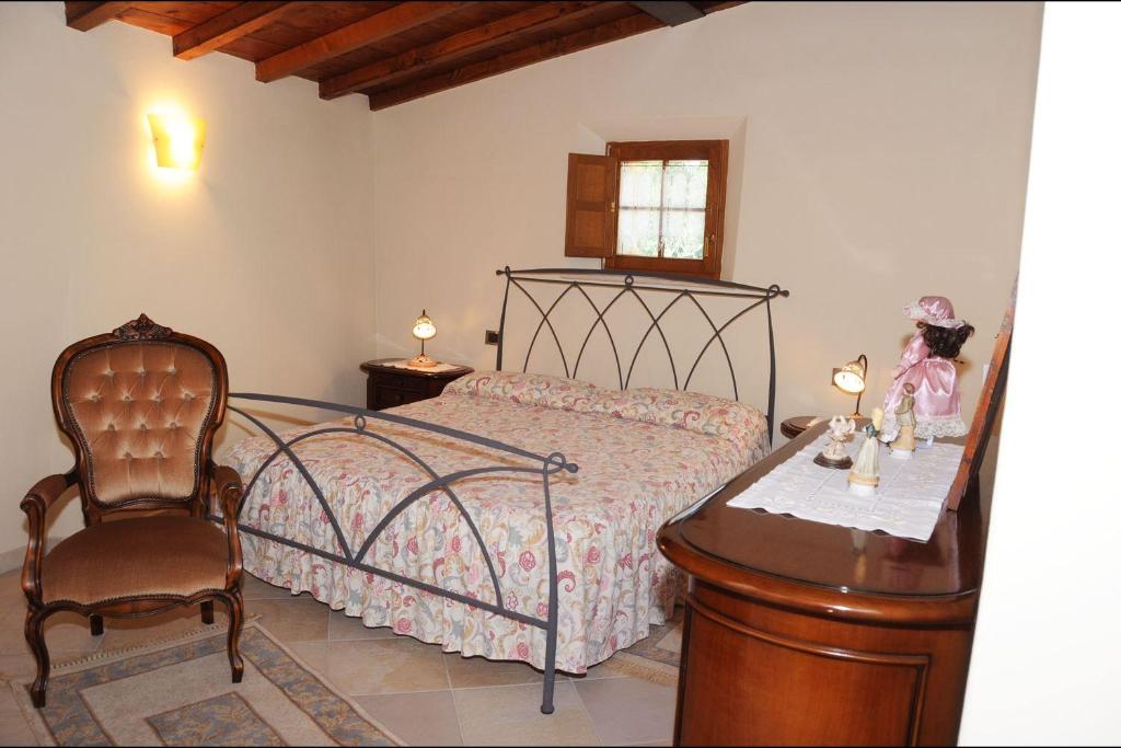 une chambre avec un lit, une chaise et une table dans l'établissement Sant'Ippolito, à Asciano