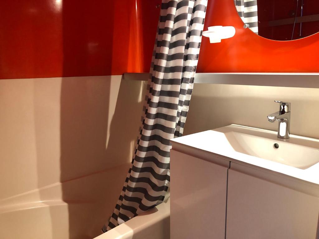 une salle de bain avec un lavabo et un rideau de douche dans l'établissement Arcadien - Appartement les Arcs 1800 - 10 personnes - 3 chambres, à Arc 1800 37 autres photos