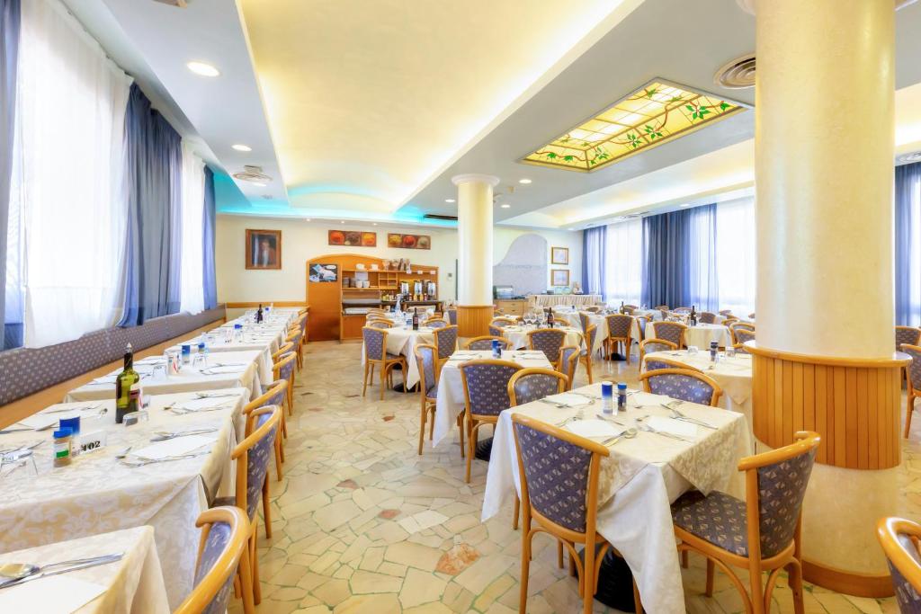 une salle à manger avec des tables et des chaises dans un restaurant dans l'établissement Hotel Harry's, à Lido di Jesolo