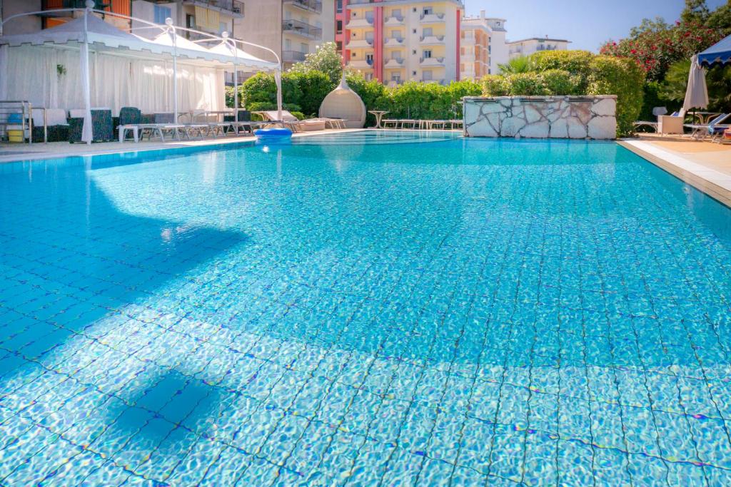une grande piscine avec de l'eau bleue dans l'établissement Hotel Harry's, à Lido di Jesolo