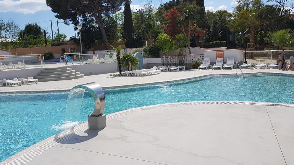 - une piscine avec une fontaine au milieu dans l'établissement Mobile Home tout confort Séléna, à Agde 37 autres photos