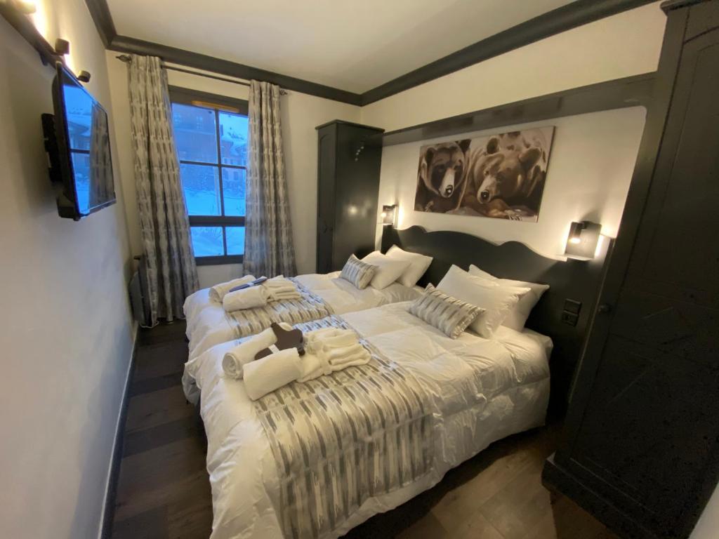 une chambre avec deux lits et une grande fenêtre dans l'établissement ARC 1950 - APPT 2 CHAMBRES/ 1 COIN NUIT LUXUEUX- SKI AUX PIEDS, à Arc 1950
