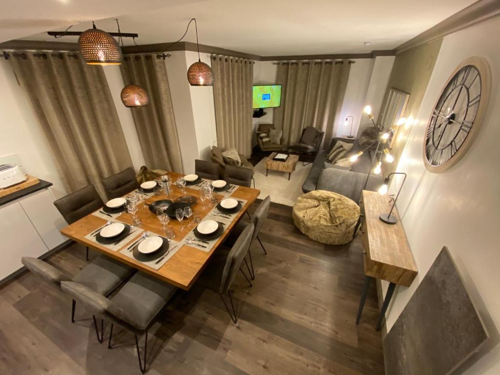 un salon avec une table à manger et un salon avec un canapé dans l'établissement ARC 1950 - APPT 2 CHAMBRES/ 1 COIN NUIT LUXUEUX- SKI AUX PIEDS, à Arc 1950