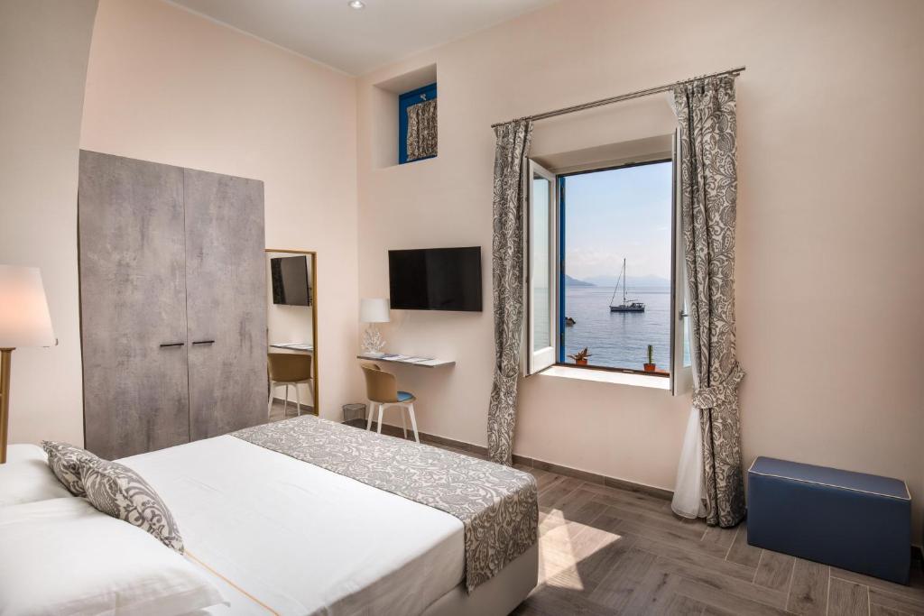 une chambre avec un lit et une grande fenêtre dans l'établissement Hotel L'Ariana ISOLE EOLIE - UNA Esperienze, à Leni