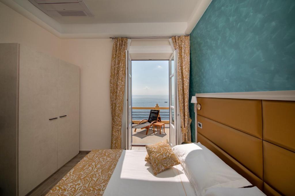 une chambre avec un lit et une vue sur l'océan dans l'établissement Hotel L'Ariana ISOLE EOLIE - UNA Esperienze, à Leni