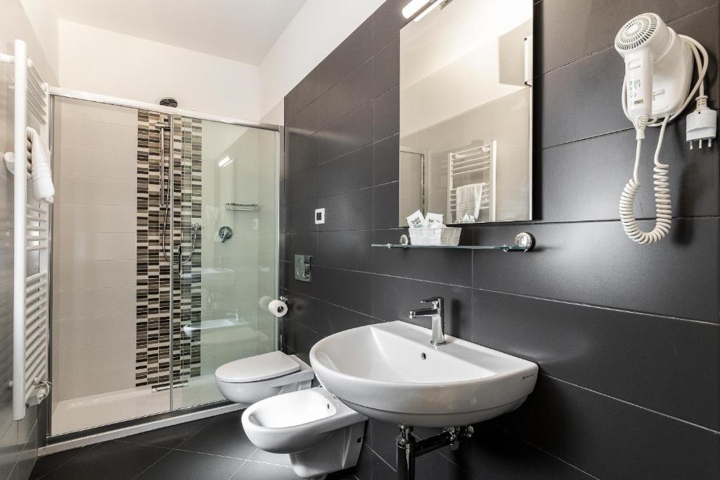 une salle de bain avec un lavabo, des toilettes et une douche dans l'établissement Hotel Mediterraneo, à Martinsicuro