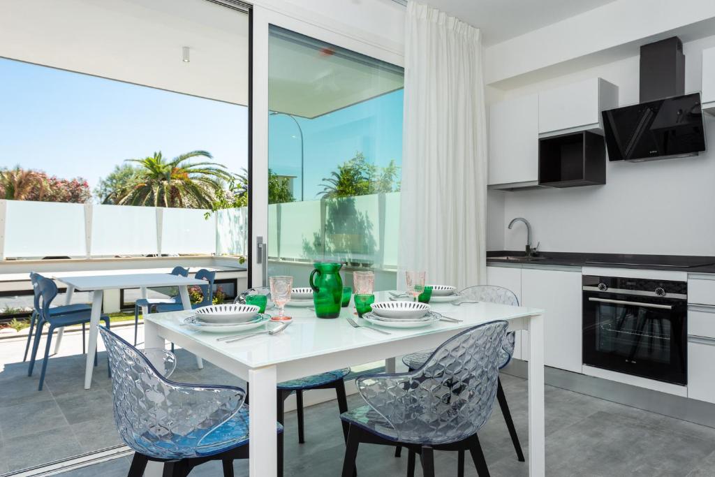 une cuisine et une salle à manger avec une table et des chaises blanches dans l'établissement Karma Resort, à San Benedetto del Tronto