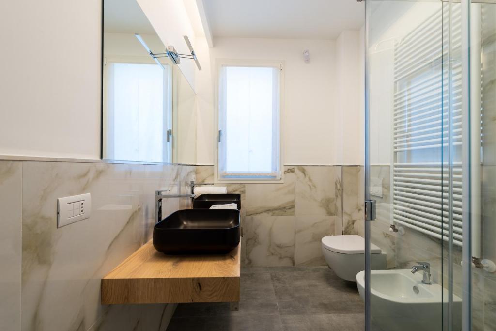 une salle de bain avec un lavabo, des toilettes et un miroir dans l'établissement Karma Resort, à San Benedetto del Tronto 52 autres photos