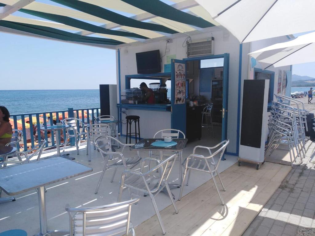 un restaurant avec chaises et tables sur la plage dans l'établissement Hotel Mariagrazia, à Calopezzati