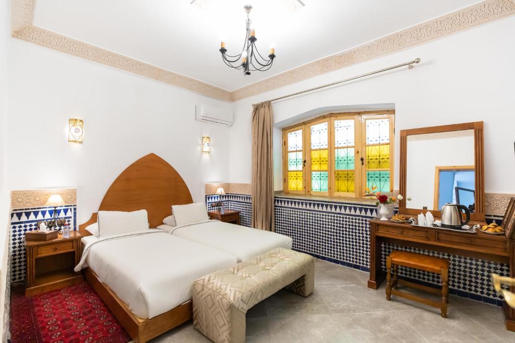 une chambre avec un lit, un bureau et une fenêtre dans l'établissement Riad Al Makan Fes & Spa, à Fès