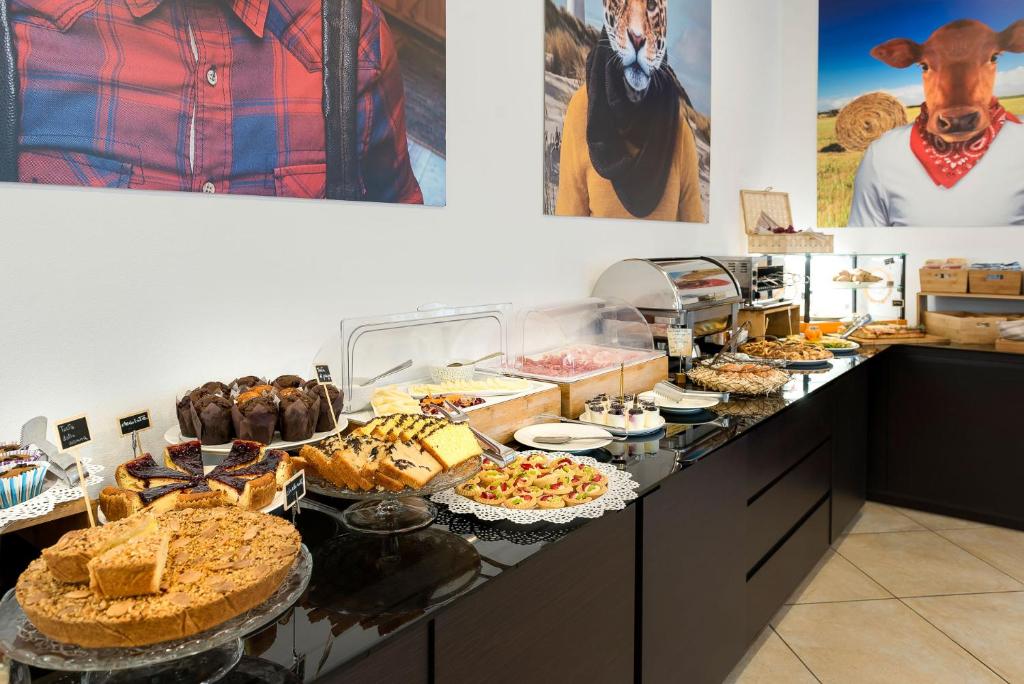 un buffet avec de nombreux types de nourriture différents sur un comptoir dans l'établissement Sovrana Hotel & SPA, à Rimini