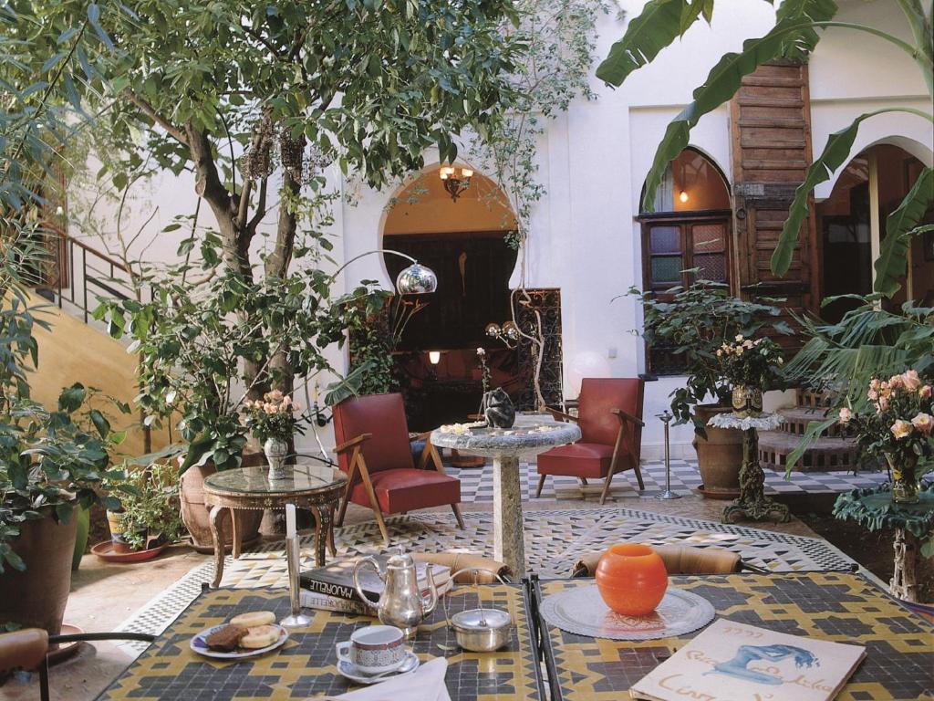 un patio avec tables, chaises et plantes dans l'établissement Riad Malika, à Marrakech