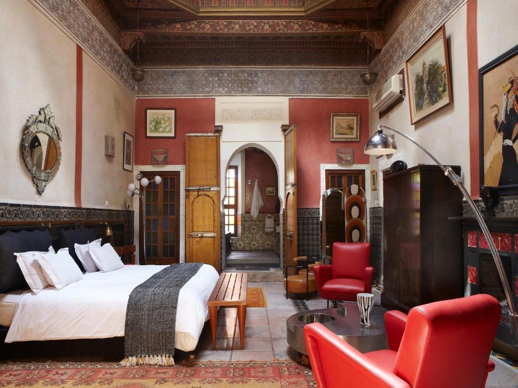 - une chambre avec un lit et des chaises rouges dans l'établissement Riad Malika, à Marrakech