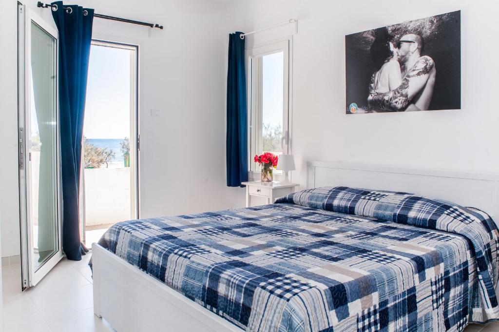- une chambre dotée d'un lit avec une couverture bleue dans l'établissement Centro Vacanze Lido Smeraldo, à Frigole