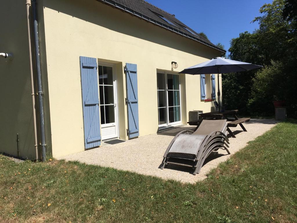 un banc et un parasol à côté d'un bâtiment dans l'établissement Gites de kermoel, Ouessant, à Kernascléden
