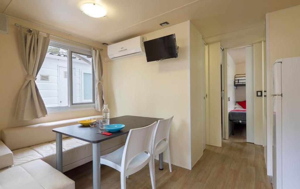 un salon avec une table et des chaises dans une pièce dans l'établissement Centro Vacanze Isuledda, à Cannigione