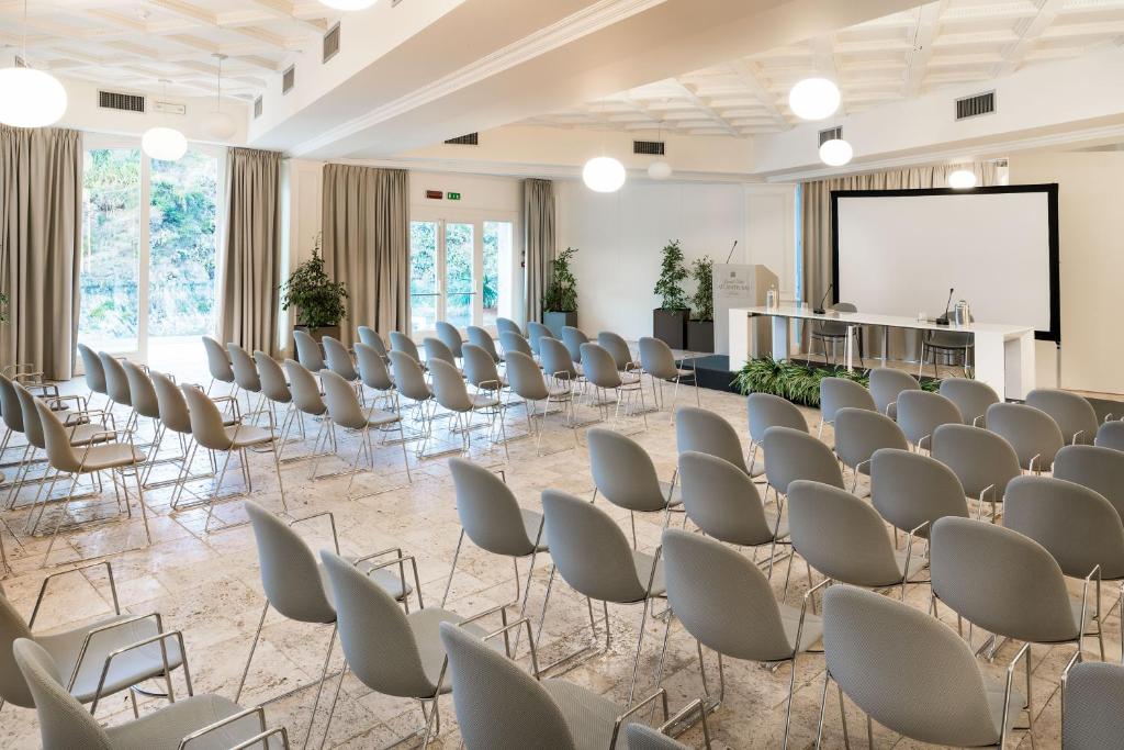 une chambre avec des rangées de chaises et un écran de projection dans l'établissement Atlantis Bay - VRetreats, à Taormine 52 autres photos