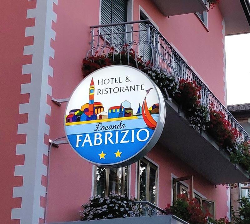 un panneau sur le côté d'un bâtiment rose dans l'établissement Albergo Ristorante Fabrizio, à Caorle