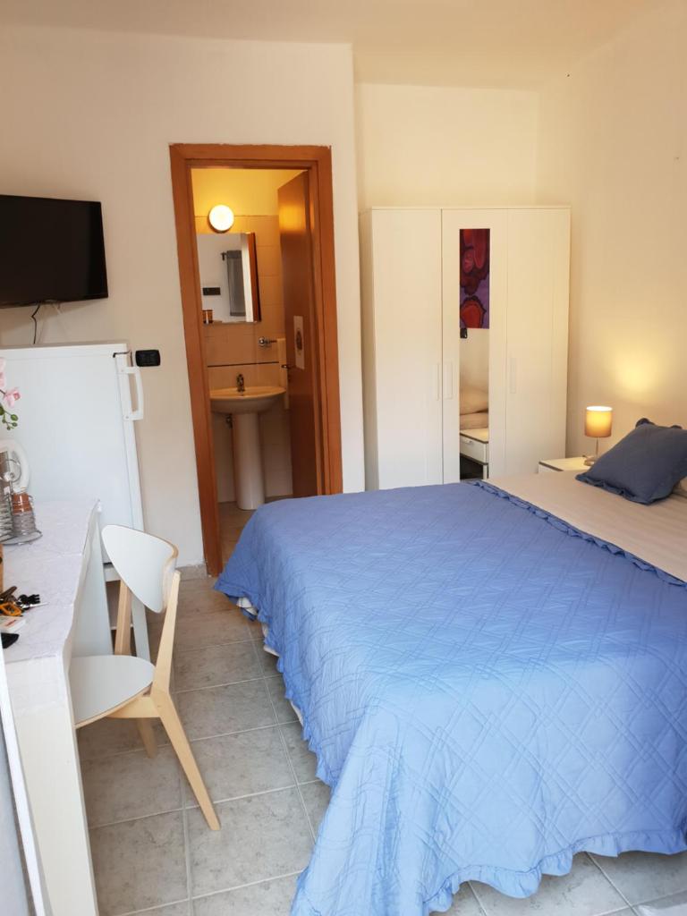 - une chambre avec un lit bleu, un bureau et une chaise dans l'établissement Rooms in the Beach, à Catane