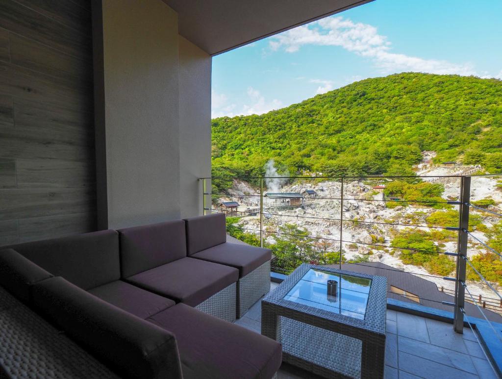 un salon avec un canapé et une table en verre dans l'établissement Unzen Kyushu Hotel, à Unzen