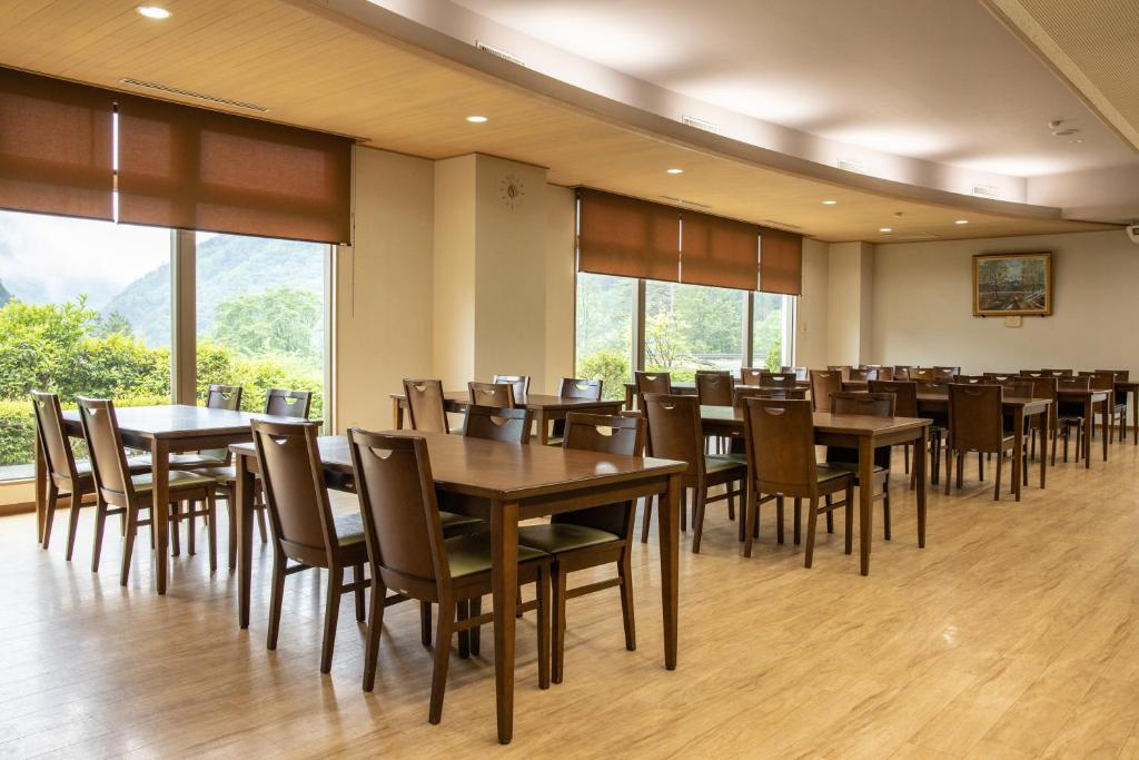une salle à manger avec tables, chaises et fenêtres dans l'établissement Hotel Miki, à Gero