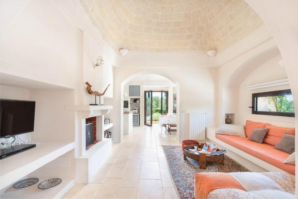un salon avec un canapé et une télévision dans l'établissement Villa Moresca dei Trulli Fernando, à Ostuni