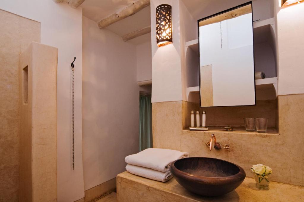 La salle de bains est pourvue d'un lavabo en bois et d'un miroir. dans l'établissement Riad Dar Hanane, à Marrakech
