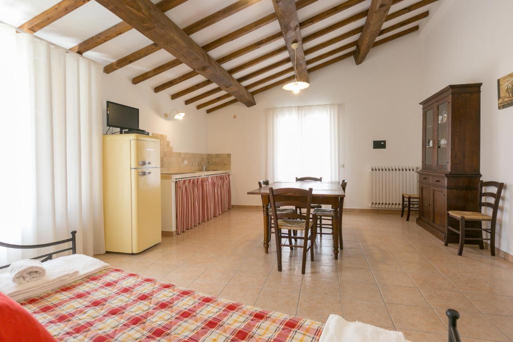 Cette chambre comprend une cuisine, une table et des chaises. dans l'établissement Cottage Zizzolo, à Riparbella