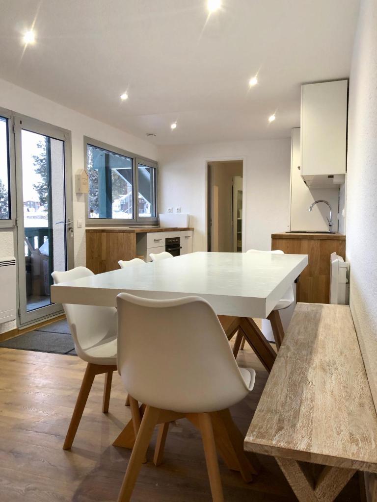 une cuisine et une salle à manger avec une table et des chaises blanches dans l'établissement L'Aire des montagnes, à Bolquère-Pyrénées 2000
