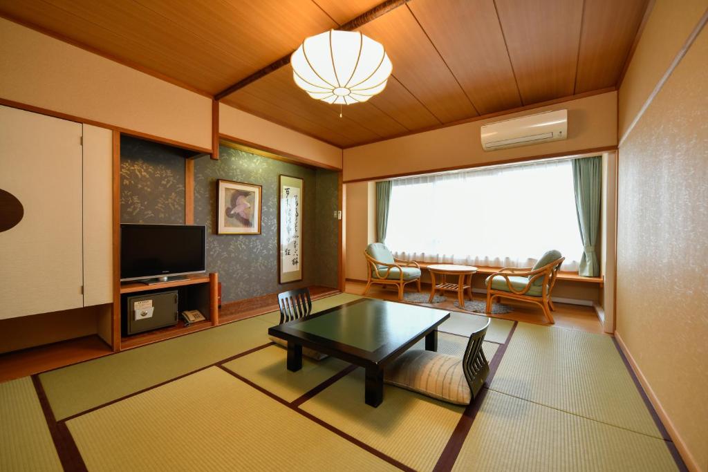 un salon avec une table et une salle à manger dans l'établissement Mimatsukan, à Shibukawa