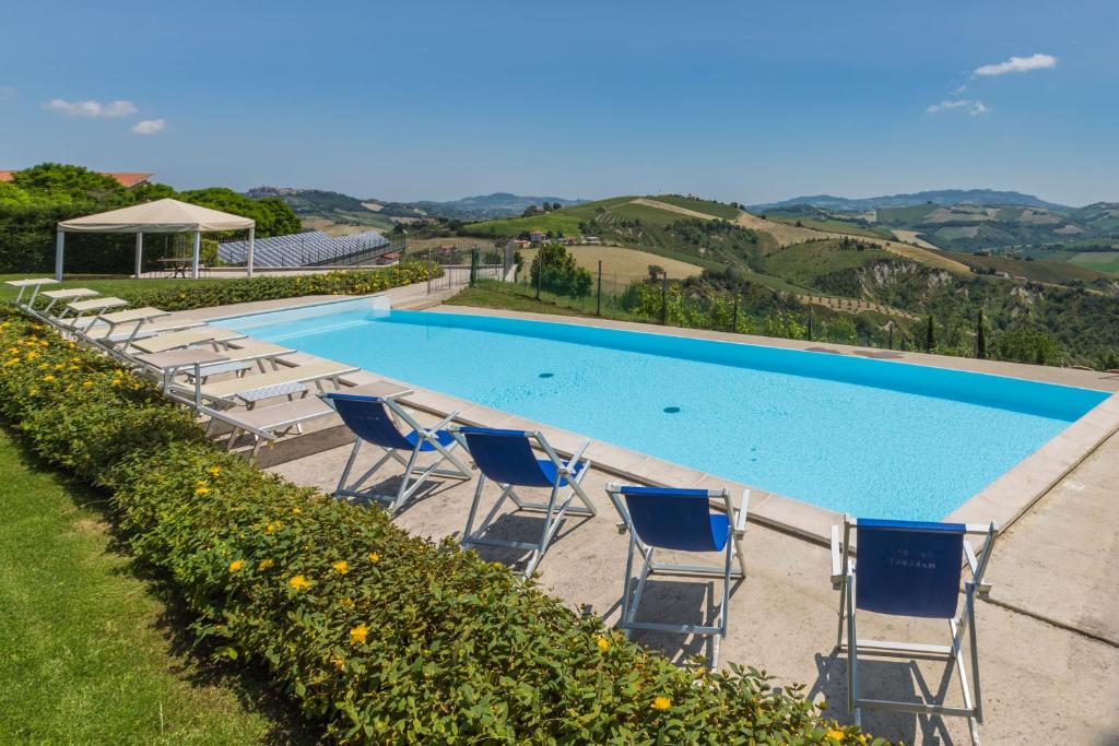 une rangée de chaises et une piscine dans l'établissement Villa delle Rose, à Montalto delle Marche
