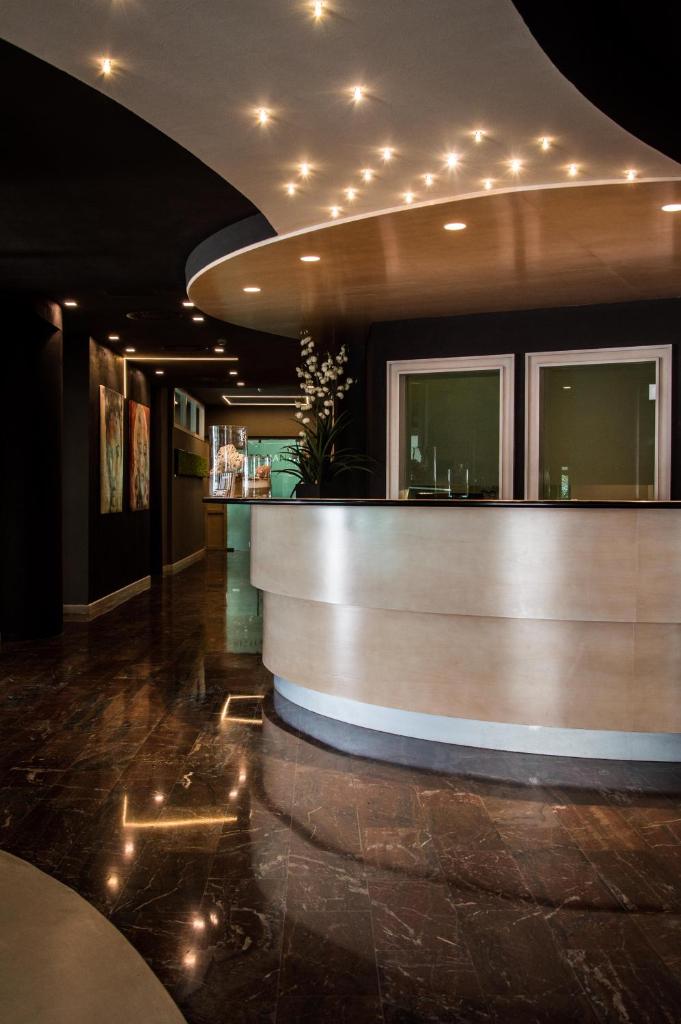 un bar dans un restaurant avec des lumières au plafond dans l'établissement International Beach Hotel, à Lignano Sabbiadoro