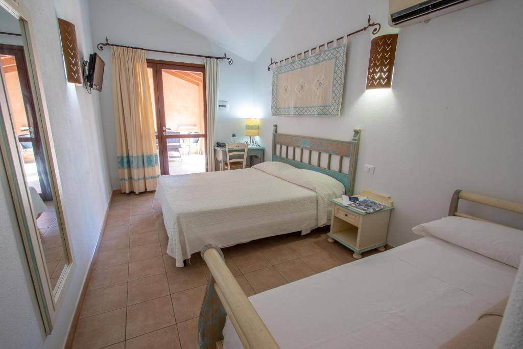 une chambre avec deux lits et un canapé dans l'établissement Alma Resort, à Castiadas