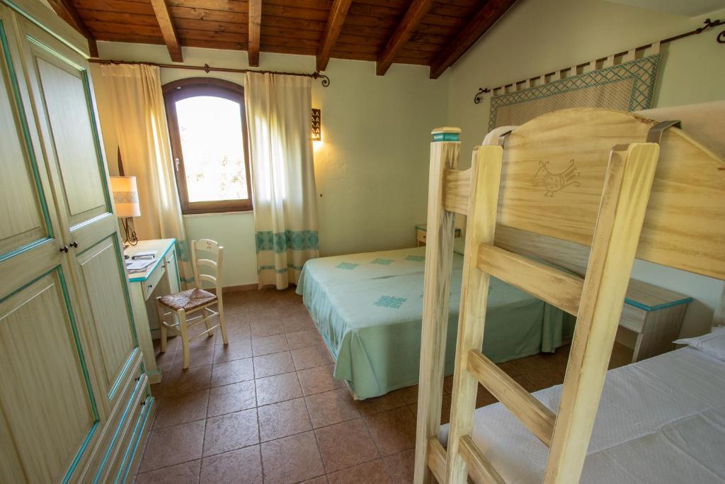 une chambre avec un lit superposé et un bureau dans l'établissement Alma Resort, à Castiadas